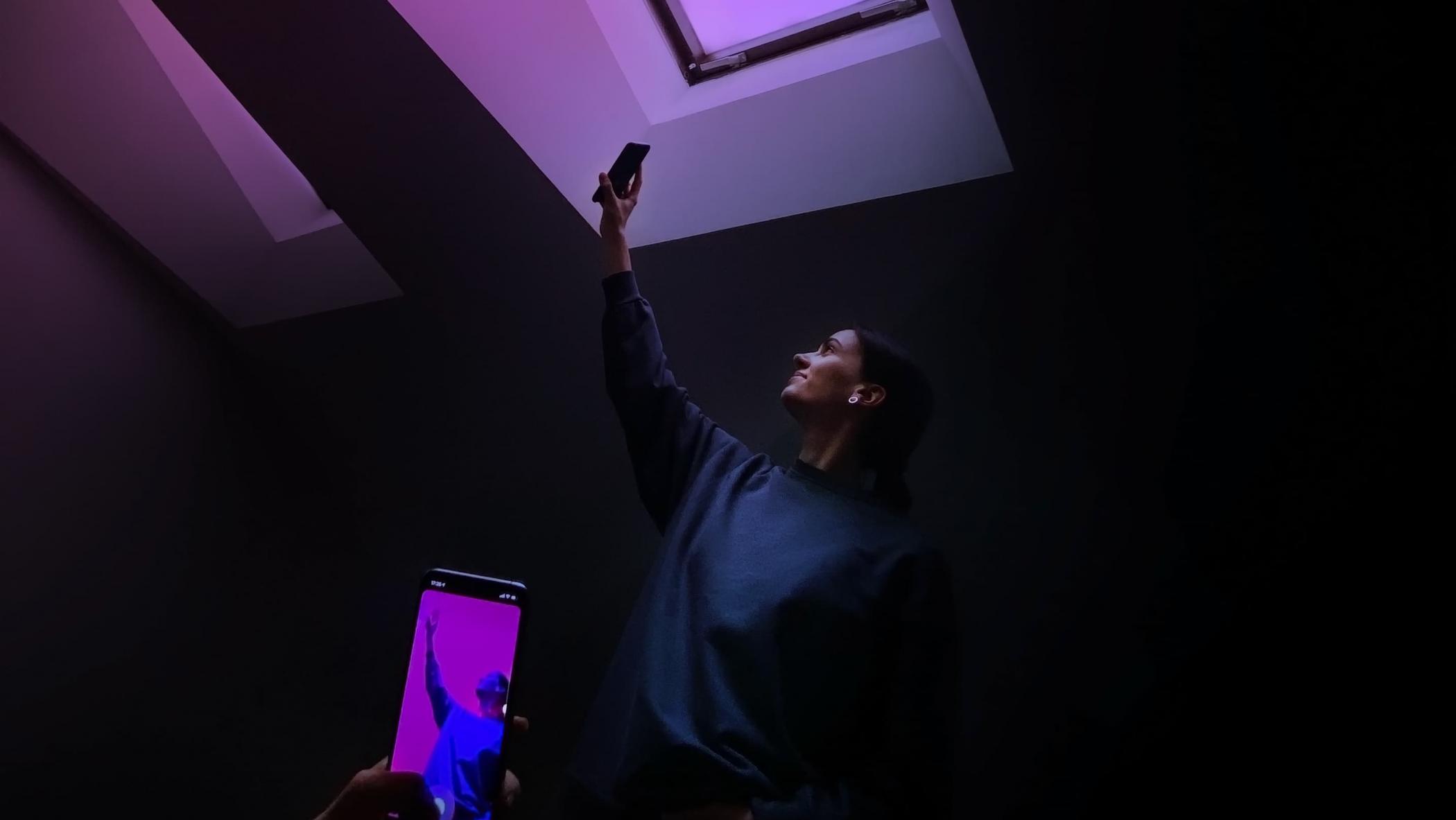 Large horizontal picture of a female posing under a skylight using a dynamic Augmented Reality (AR) Instagram effect for her picture